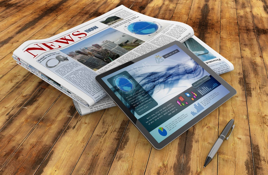 daily newspaper, tablet and pen on wooden desk